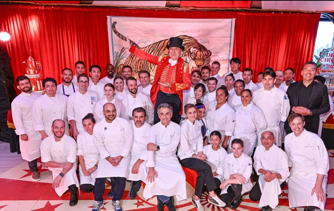 A large group of chefs and staff gathered together, showcasing teamwork in a festive environment.