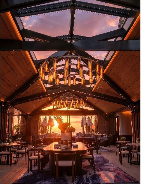 A stylish rooftop event space featuring elegant decor, ample seating, and stunning sunset views in Manhattan.